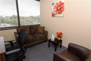 office waiting area chairs couch window blinds wall art