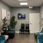 office waiting area blue chairs wall art plant christmas tree end table