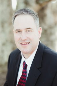 man slight smile suit tie