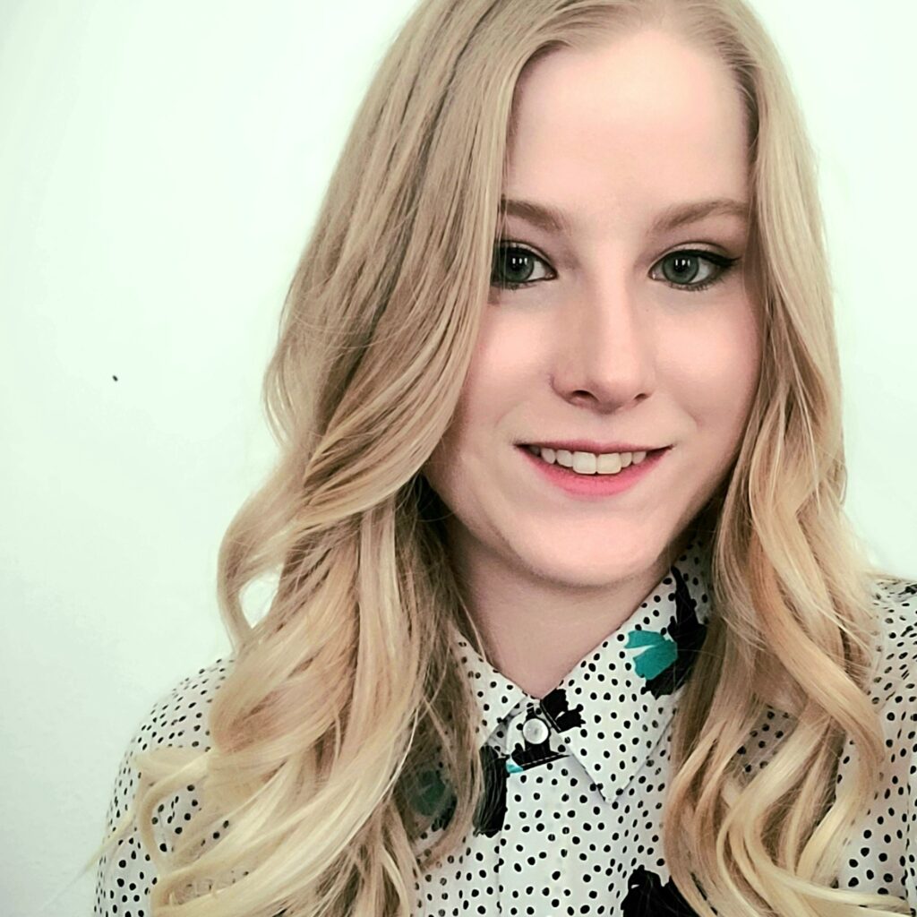 Chelsea Cornett Photo Smiling woman with long blonde hair wearing a polka dot blouse.