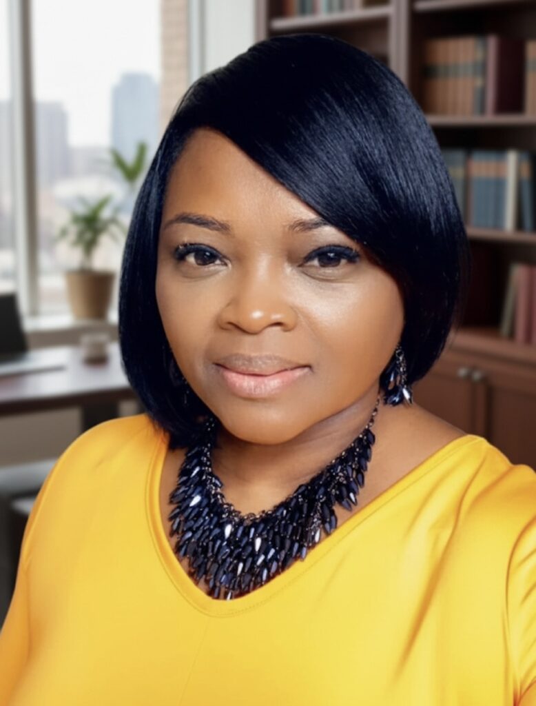 Woman with a sleek dark bob wearing a yellow top and black statement necklace