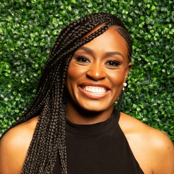 Tykesia Hathorne, therapist in black top against green hedge background